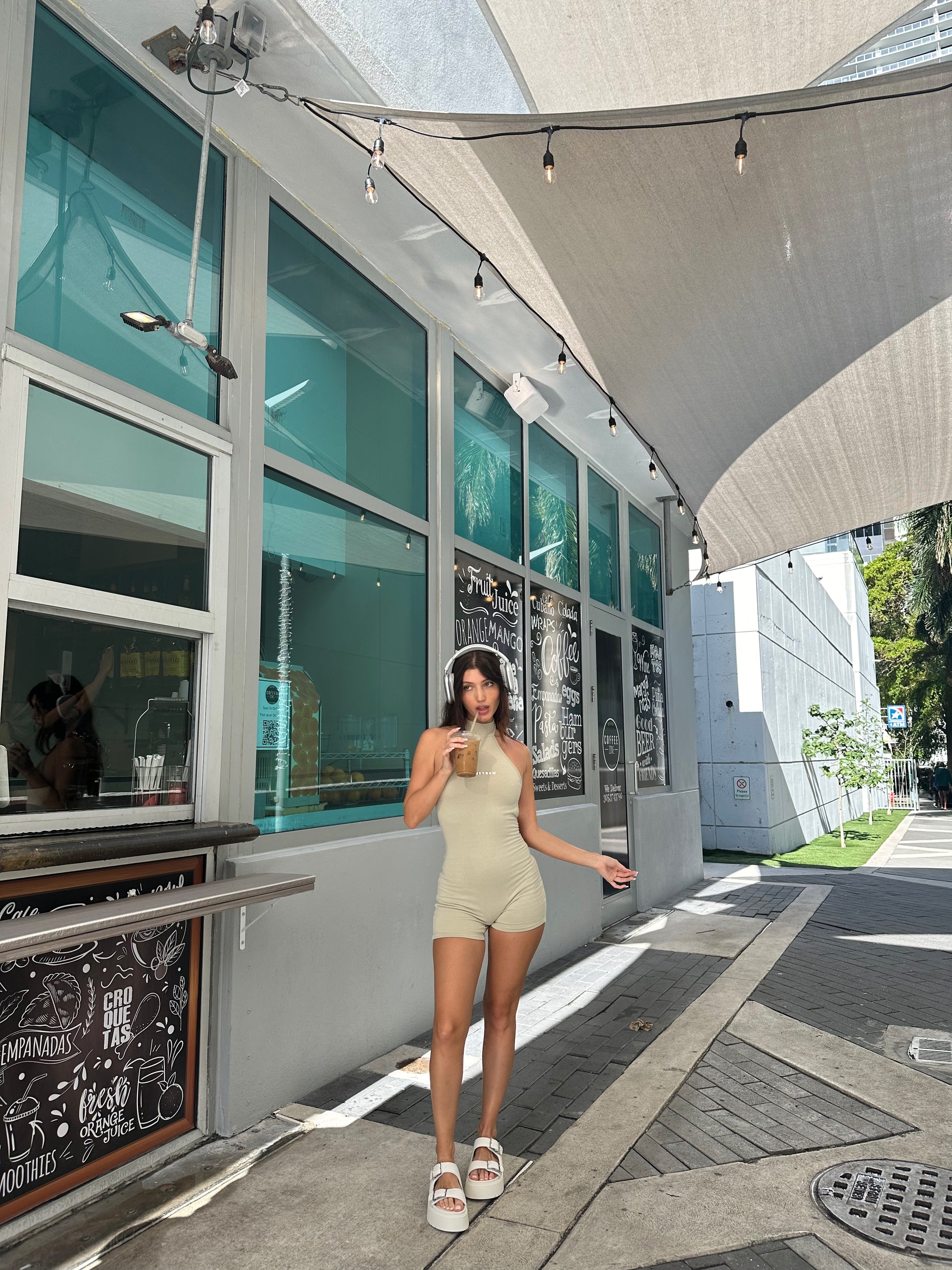 honeydew lounge girl wearing stone-colored high neck backless onesie playsuit